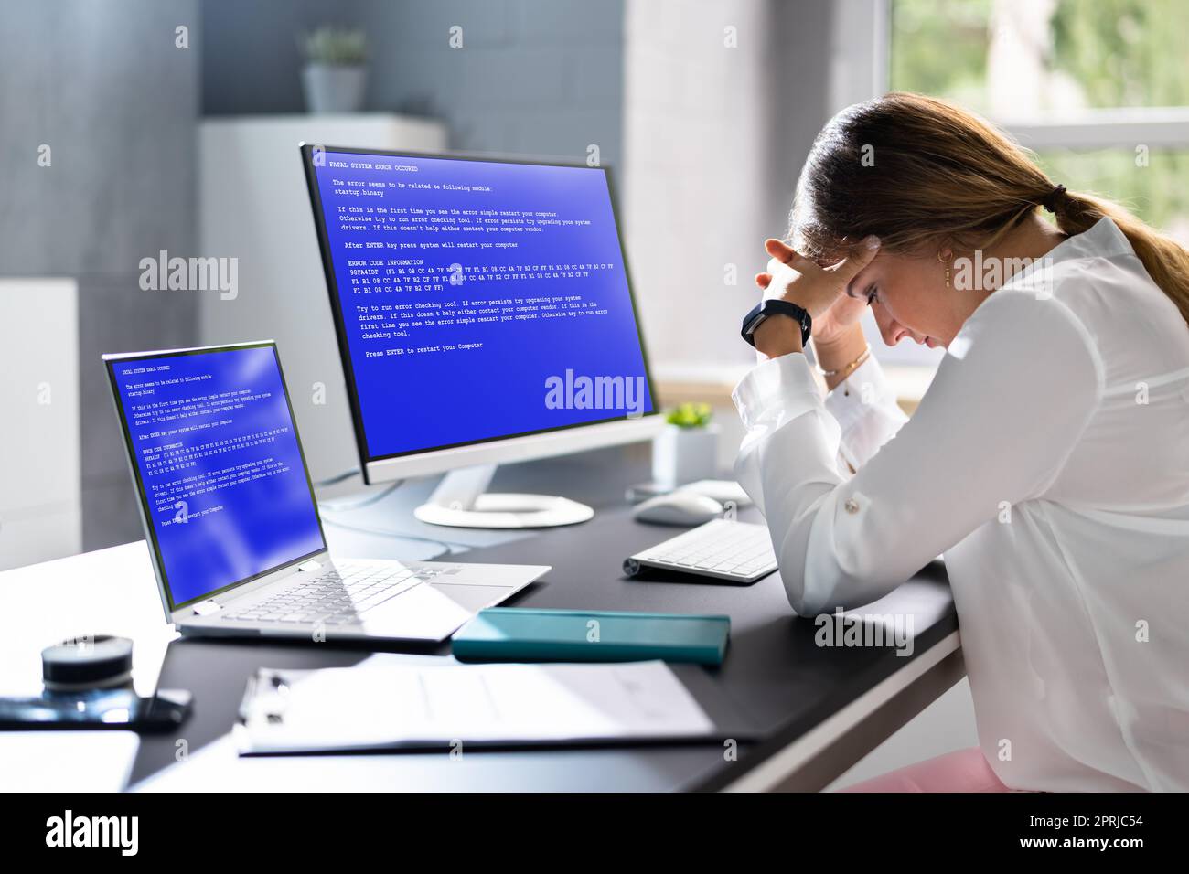 Femme inquiète à l'ordinateur avec écran de défaillance du système Banque D'Images