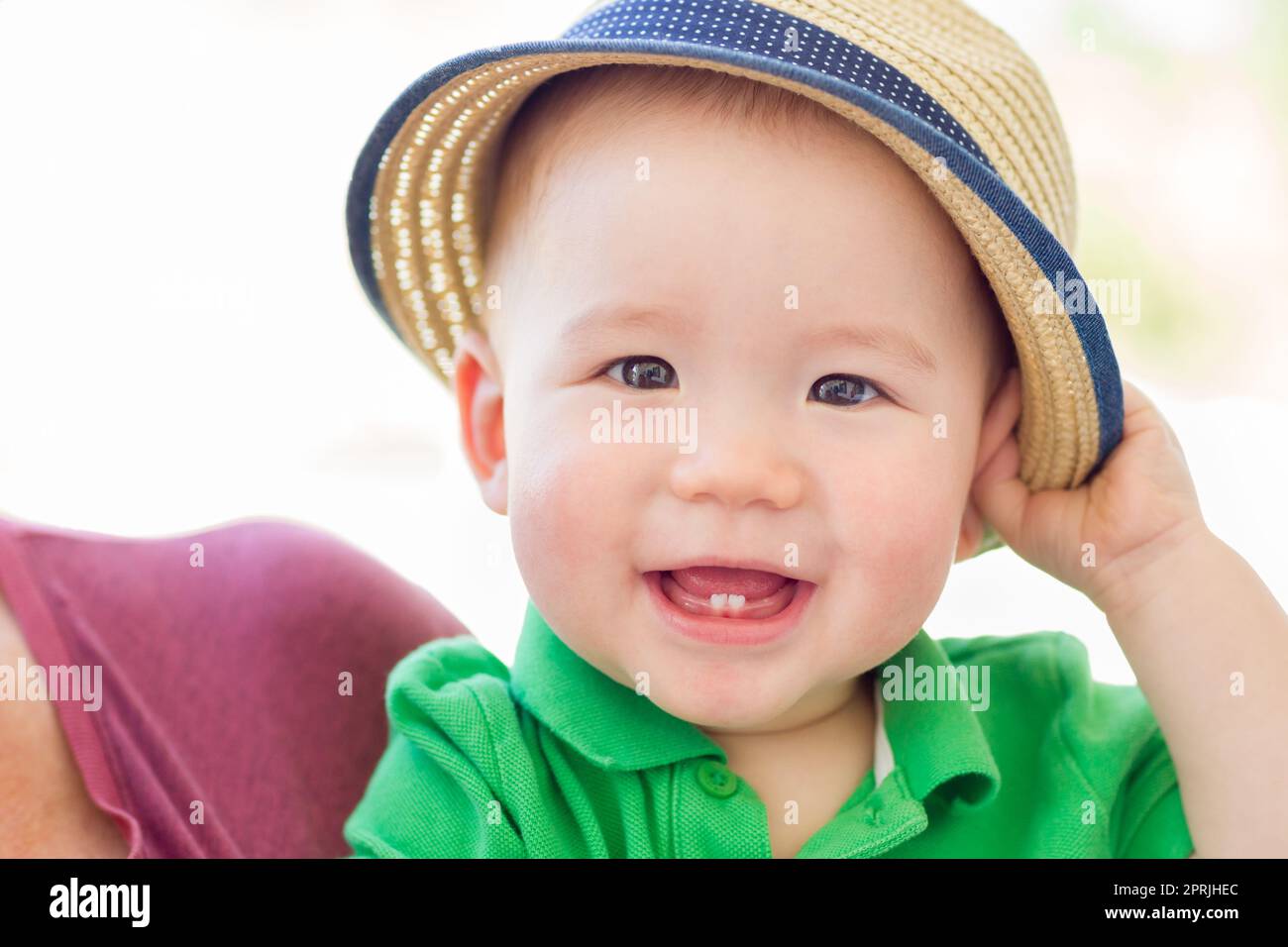 Portrait of a Happy Mixed Race Woman Baby Boy chinois et portant son chapeau Banque D'Images