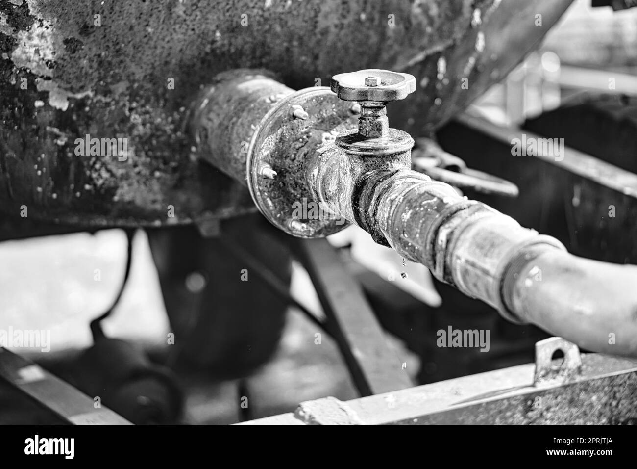 Robinet d'un réservoir d'eau ouvert .Des gouttes tombent du tuyau.Environnement rustique Banque D'Images