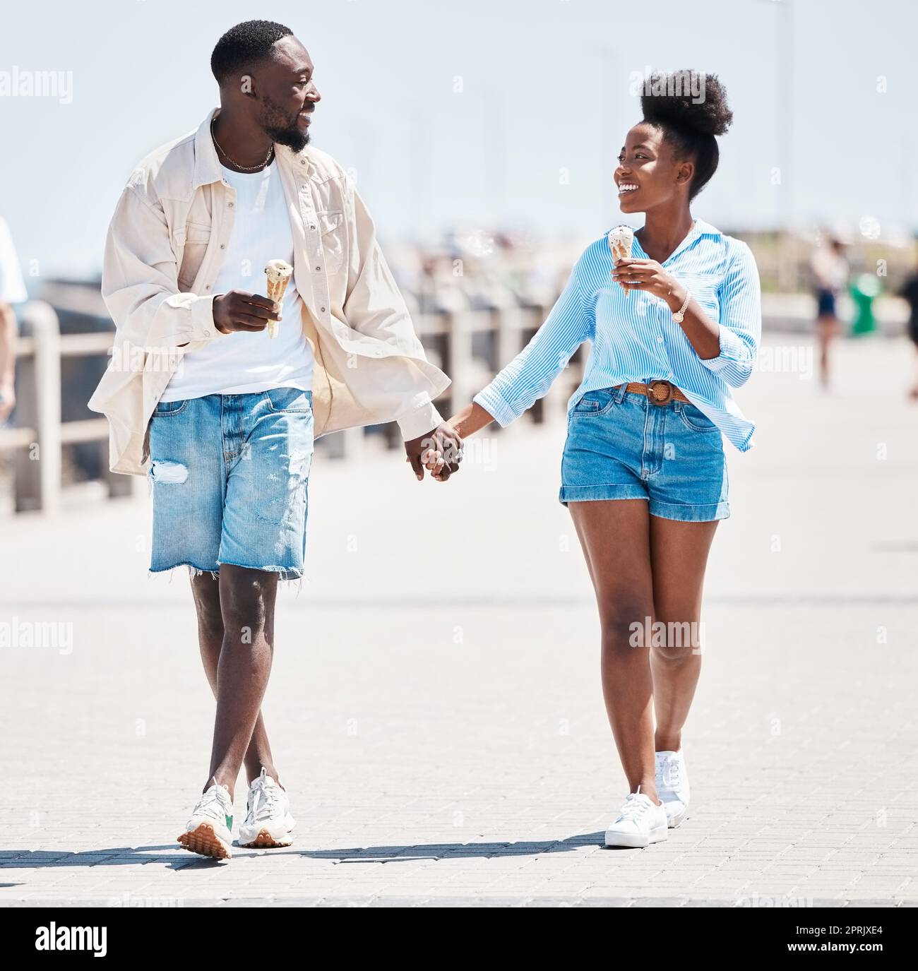 Couple glace, promenade d'été marche et amour, détente et plaisir sans souci ensemble en plein air. Les jeunes noirs tiennent la main, sourient les partenaires à une date et entretiennent une relation romantique heureuse le jour ensoleillé Banque D'Images