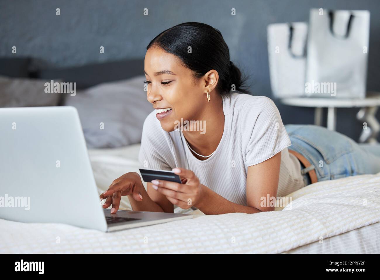 Carte de crédit, achats en ligne et femme fintech avec ordinateur portable, paiement et financier Internet ou banque web. Economie, finances et achat et commande de produits pour filles sur le site Web ou l'application sur le lit de la maison. Banque D'Images