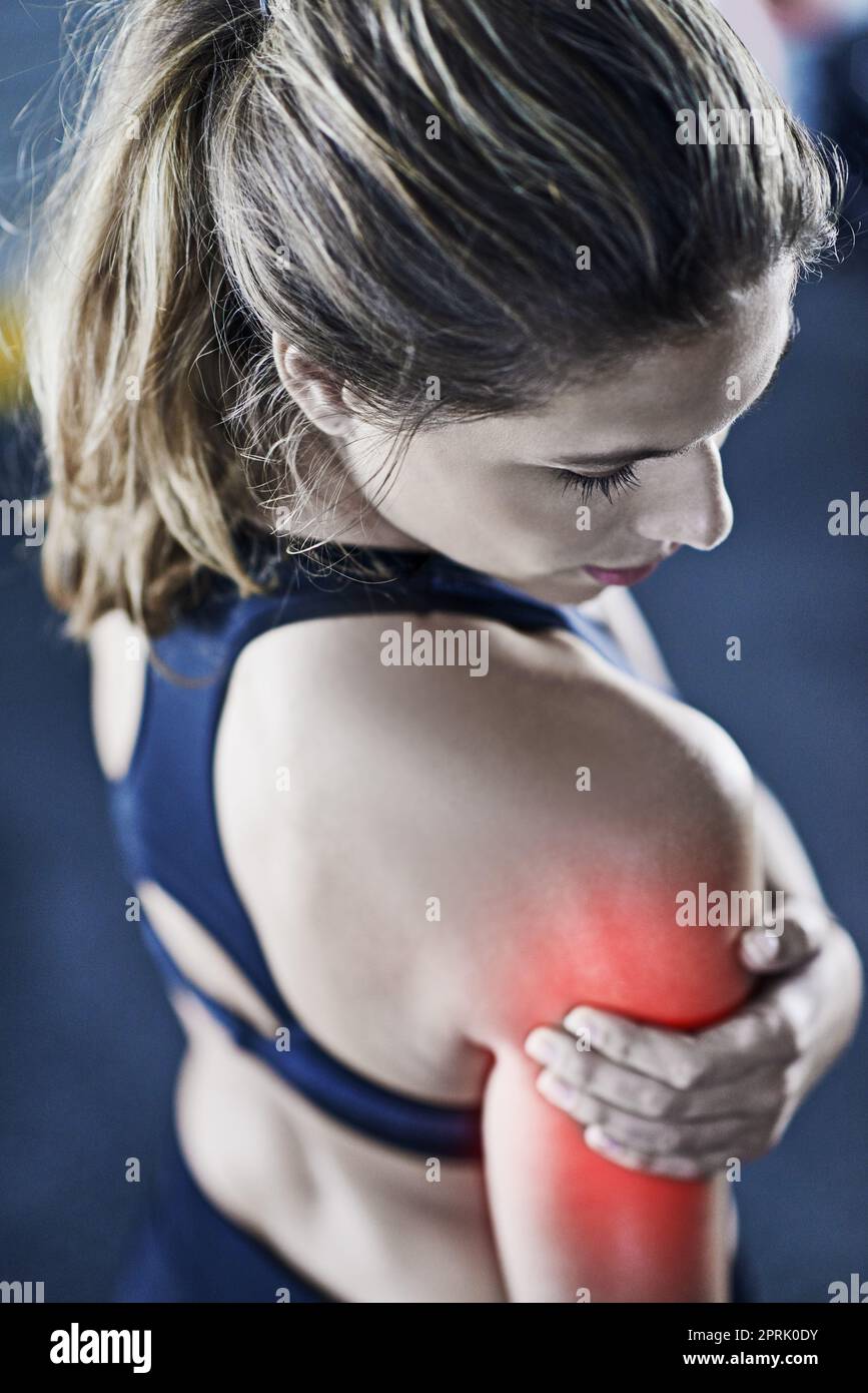 Une jeune femme qui tient son épaule blessée est surlignée en rouge. Banque D'Images