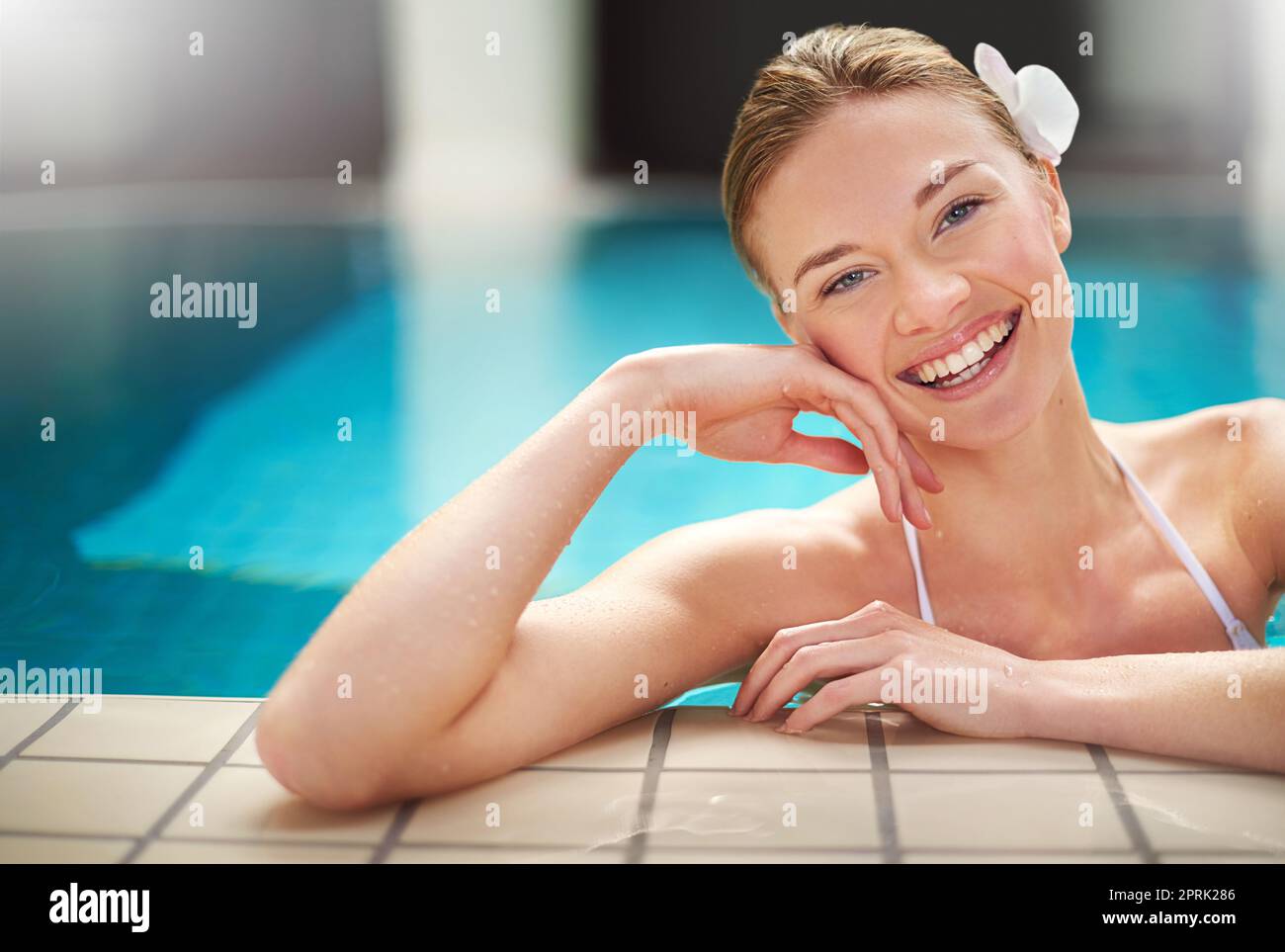 Le sourire qu'une baignade rafraîchissante pouvait donner. Une jeune femme se détendant dans la piscine dans un spa. Banque D'Images