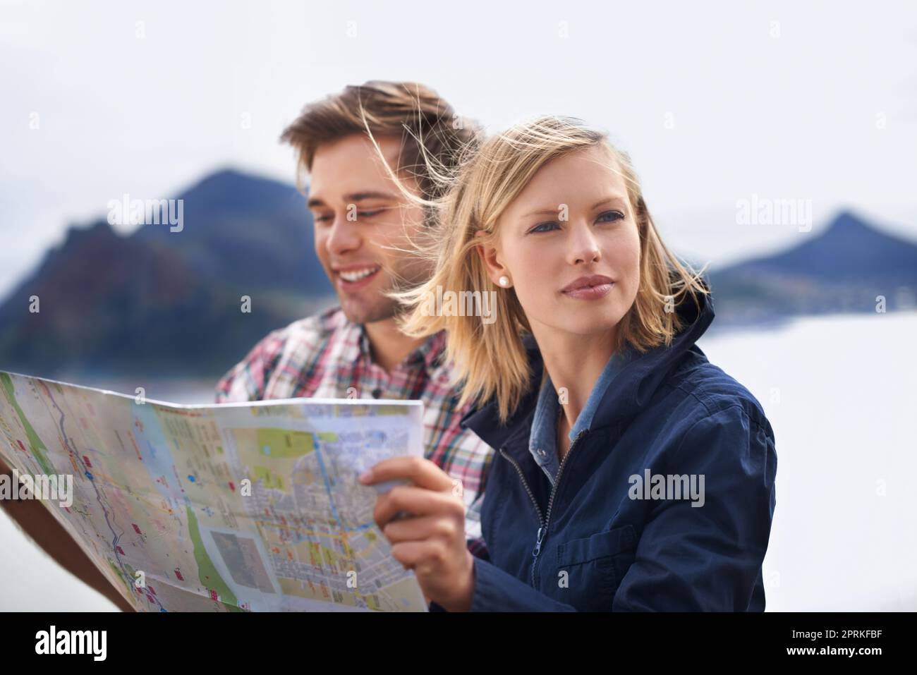 Trouver nos roulements. Une photo d'un jeune couple regardant une carte sur leur voyage en voiture Banque D'Images