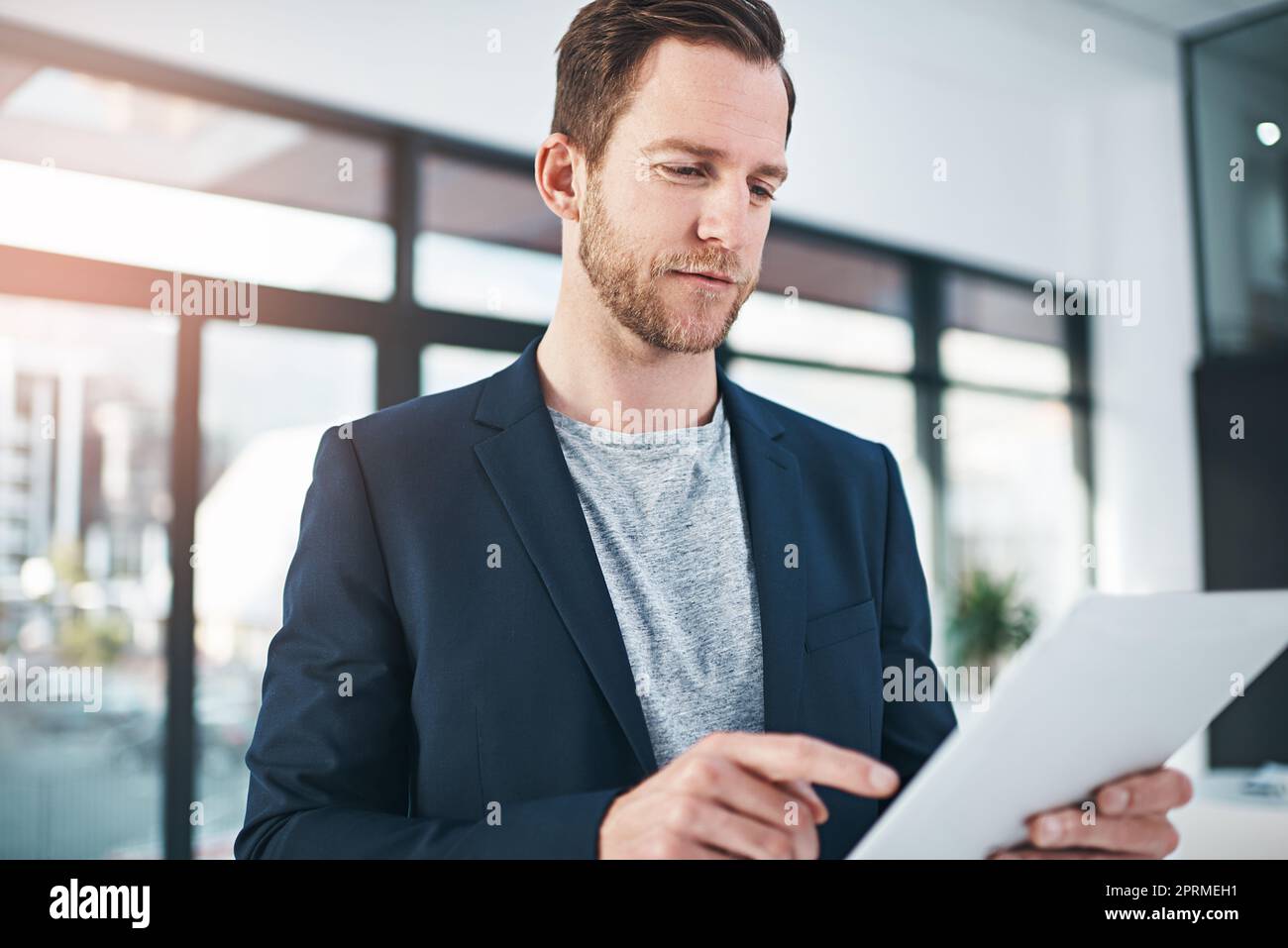 Une journée moyenne au bureau. Un homme d'affaires prospère utilisant sa tablette au bureau. Banque D'Images