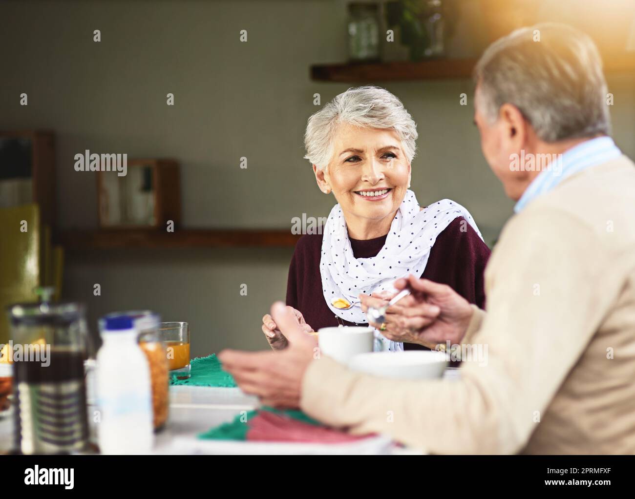 Commencez votre journée par une entreprise de personnes aimées. Un couple de personnes âgées heureux prenant le petit déjeuner ensemble à la maison. Banque D'Images