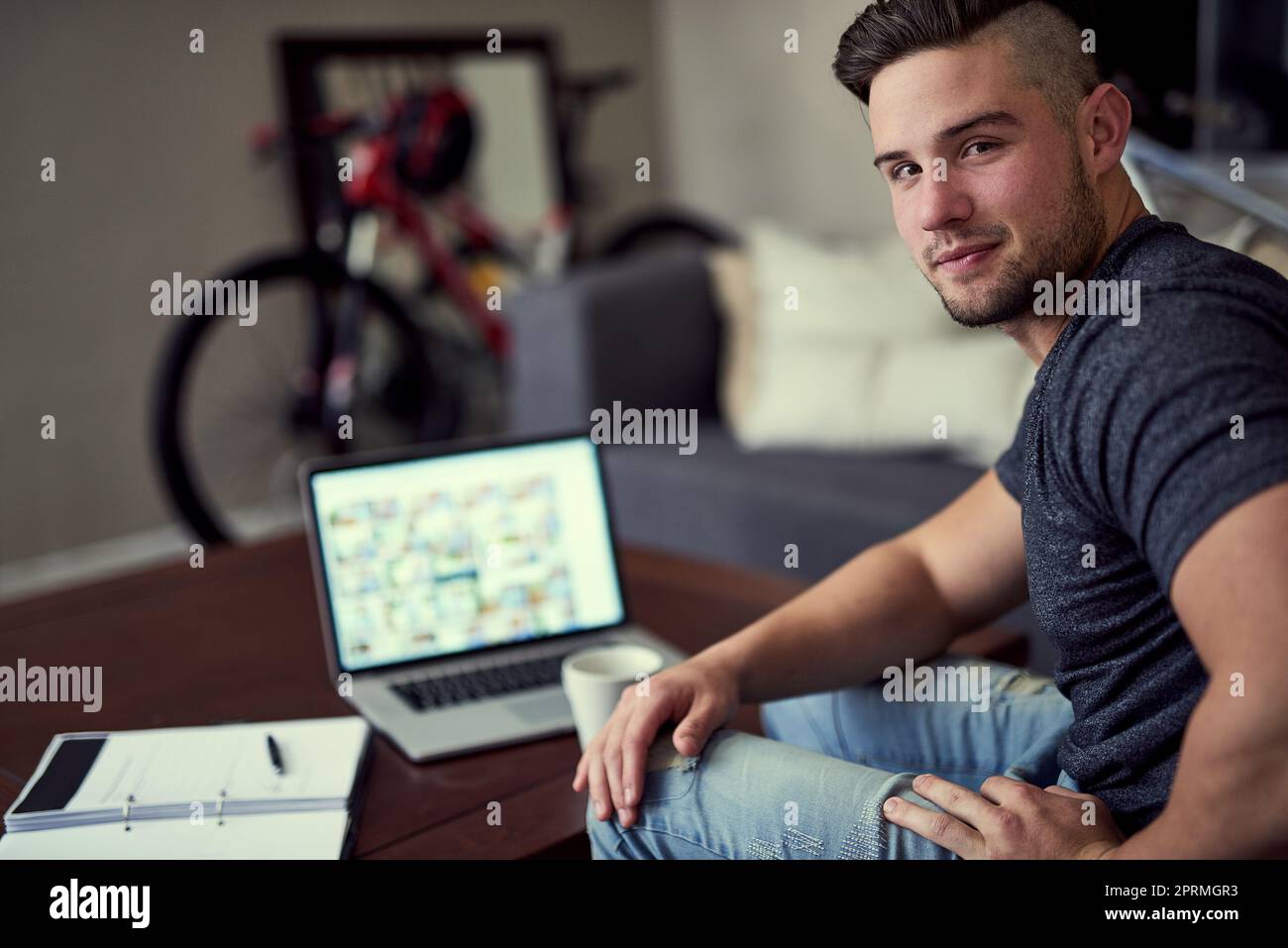 Visez haut, travaillez dur. Portrait d'un jeune homme heureux utilisant son ordinateur portable pour travailler de la maison. Banque D'Images