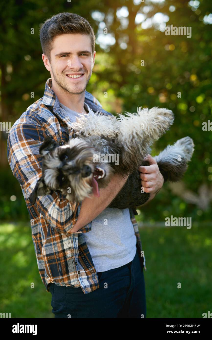 C'est ce à quoi ressemble l'amour inconditionnel. Un homme jouant avec son chien dehors. Banque D'Images