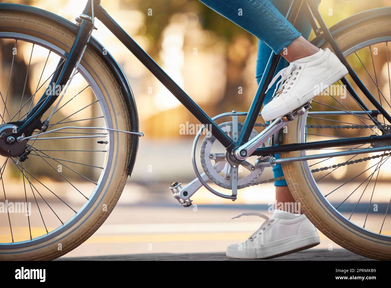 Vélo, chaussures et vélo avec une femme cycliste à l'extérieur sur la route ou la rue pendant la journée. Sport, exercice physique et fitness avec une femme sur le transport avec roues et pédales Banque D'Images