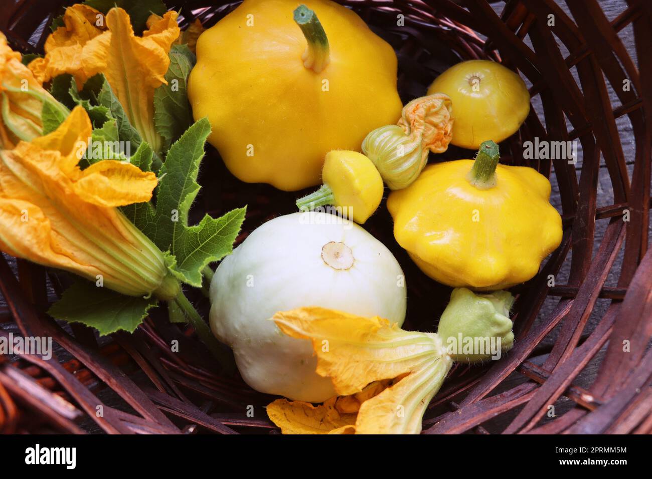 Belle patissonsin jaune et blanc un panier sur la table, une récolte fraîche de légumes. Vue de dessus Banque D'Images