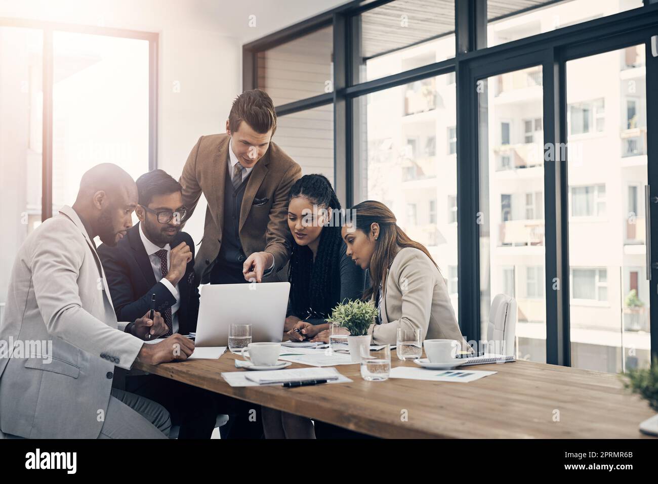 Cela vaut la peine d'être exploré. un groupe de jeunes hommes d'affaires utilisant un ordinateur portable lors d'une réunion dans un bureau moderne Banque D'Images