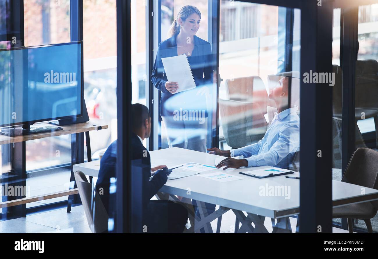 Présentation numérique par le responsable d'équipe, travail d'équipe pour les réunions d'affaires à la table de la salle de réunion et dans la salle de bureau vitrée. Encadrement des employés des responsables Big Data, atelier de formation sur la chaîne de blocs et document de stratégie financière Banque D'Images