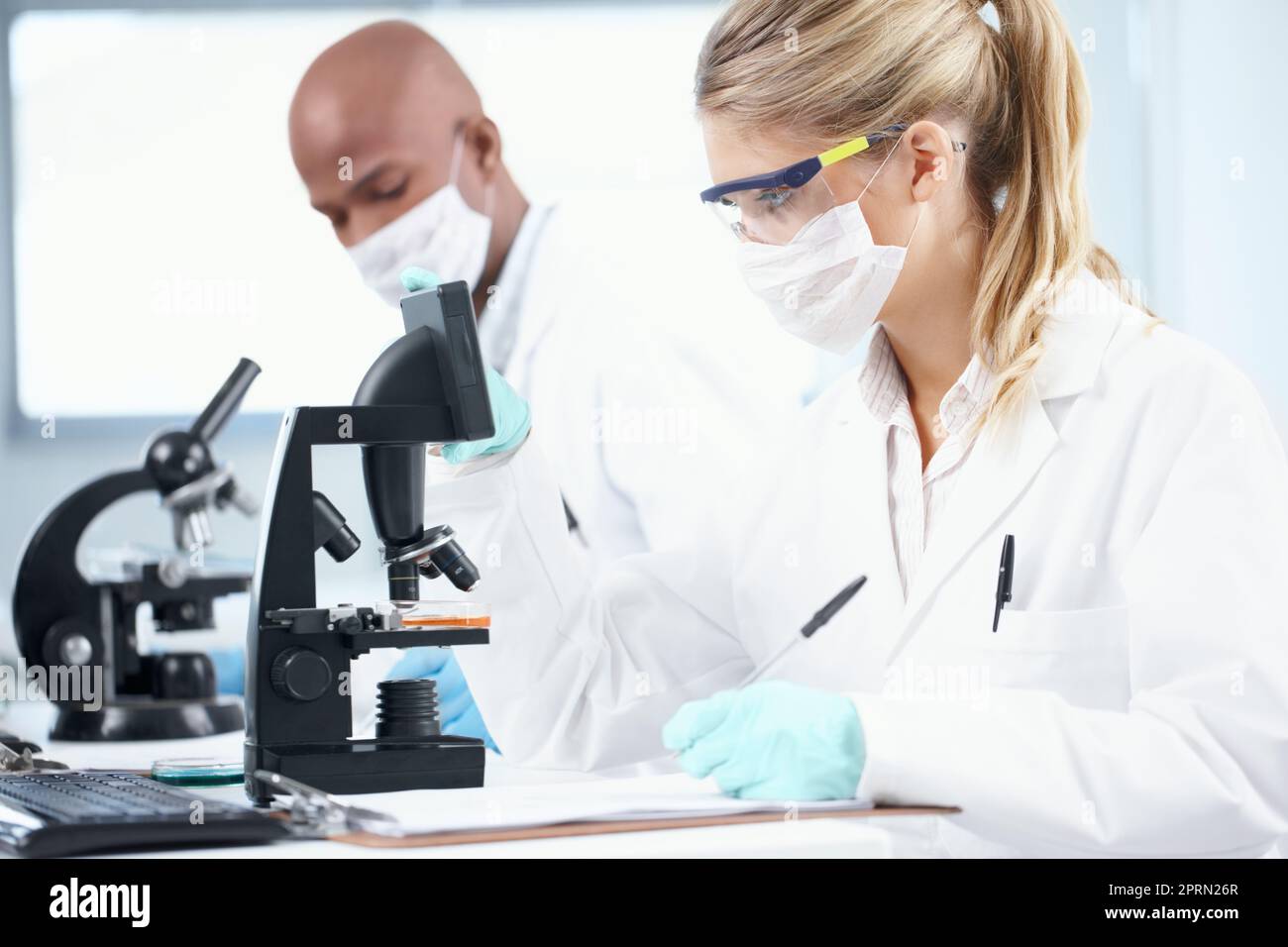La recherche aide à améliorer la médecine moderne. Deux scientifiques travaillant dans le laboratoire tout en prenant des notes. Banque D'Images