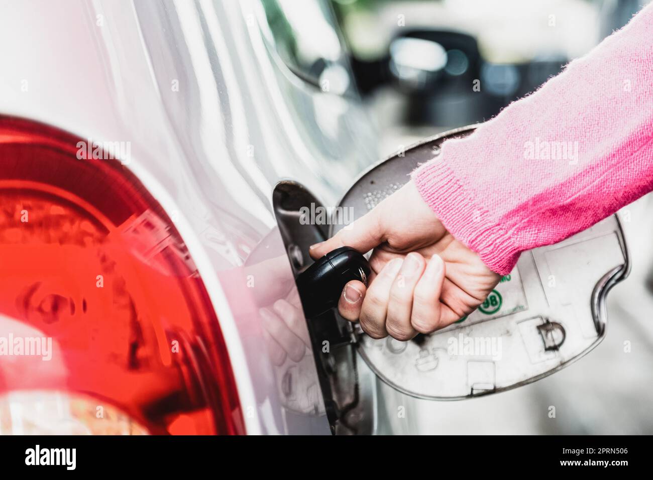 Gros plan du réservoir de carburant de voiture à ouverture manuelle femelle avec une clé. Banque D'Images