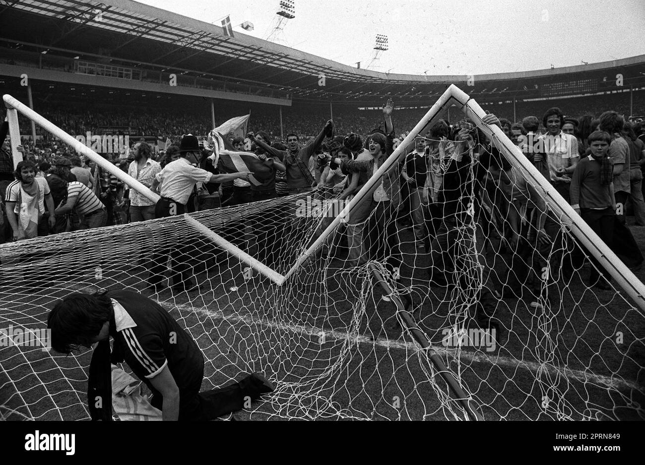 Photo du dossier en date du 04-06-1977 d'Un poteau de but a été écrasé et déchiré alors qu'un policier a essayé de calmer certains des milliers de fans écossais en train de courir sauvage sur le terrain au stade de Wembley après la défaite de l'Écosse contre l'Angleterre en 2-1. Date de publication : jeudi 27 avril 2023. Banque D'Images