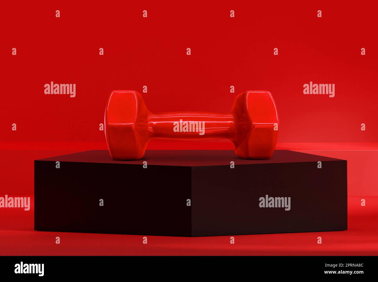 Haltères sur le podium noir du pentagone dans le studio rouge Banque D'Images