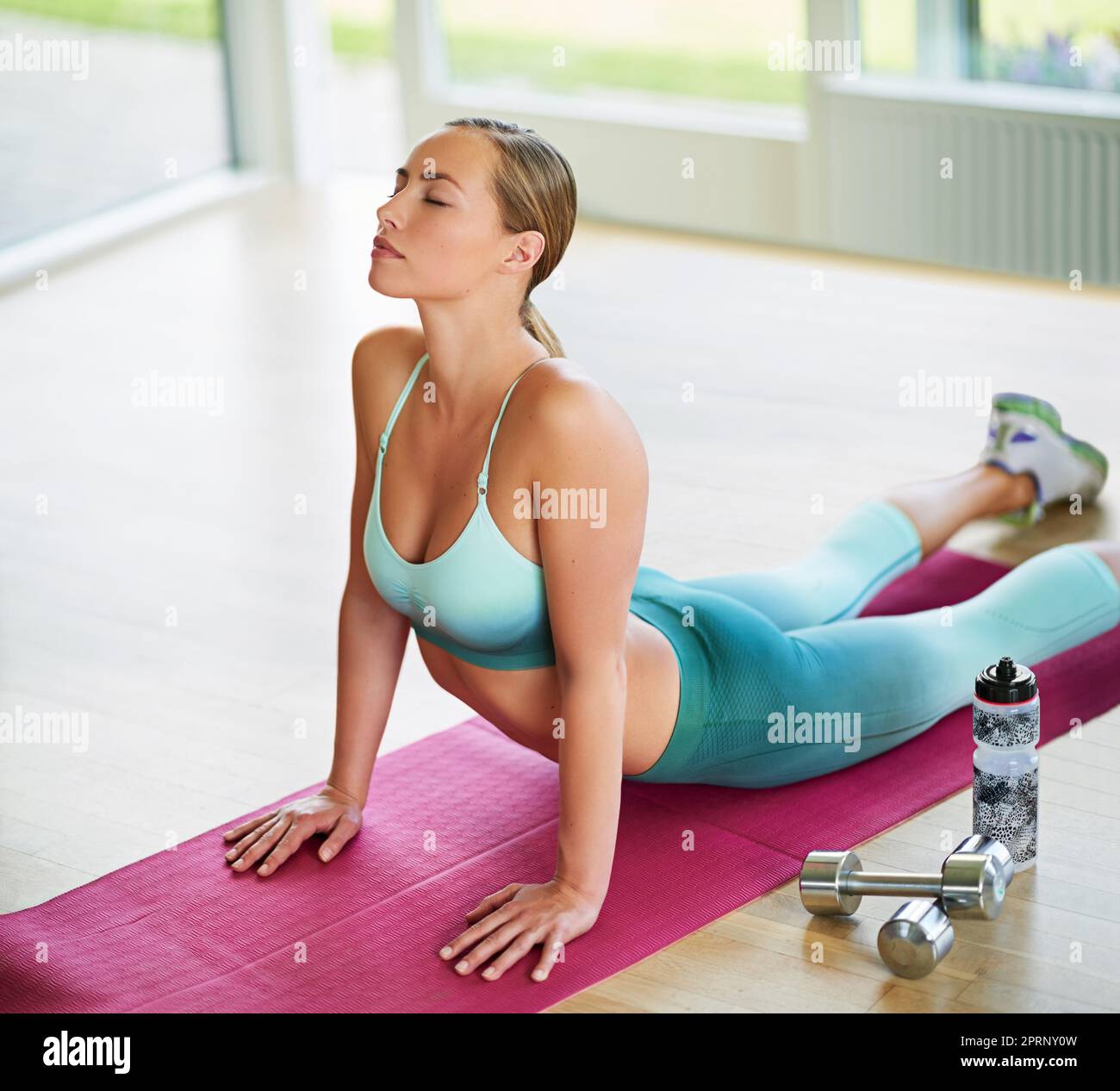 Le yoga est la partie la plus importante de sa journée. Une jeune femme attrayante faisant du yoga à la maison. Banque D'Images