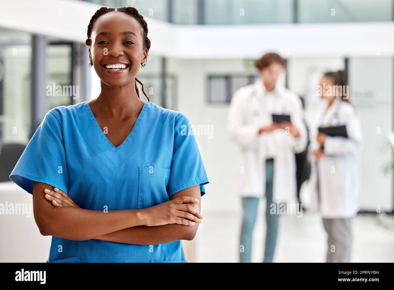 Infirmière, soins de santé et médecine avec une femme travaillant dans les soins de santé pour la santé, le bien-être ou l'assurance dans un hôpital. Portrait d'une étudiante en médecine ou de bras debout professionnels croisés à l'intérieur Banque D'Images