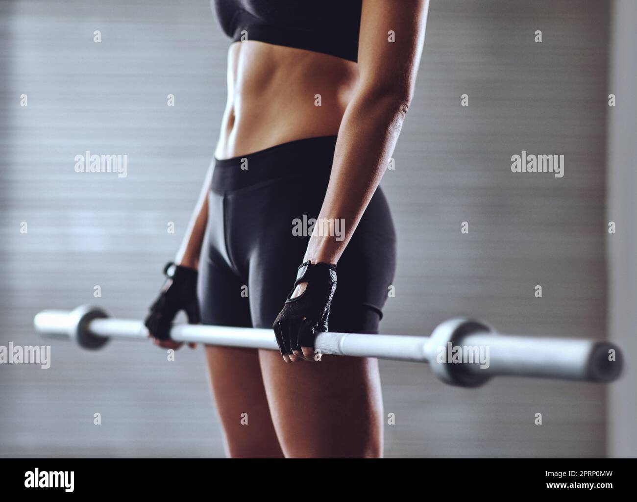 Des entraînements solides créent des corps solides. Une femme s'entraîne avec des poids à la salle de gym. Banque D'Images