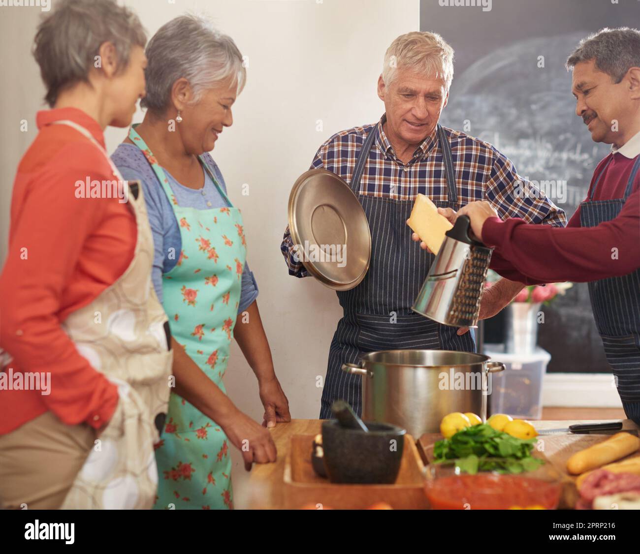 De bonnes choses viennent à ceux qui cuisinent. Un groupe de personnes âgées qui cuisinent dans la cuisine. Banque D'Images