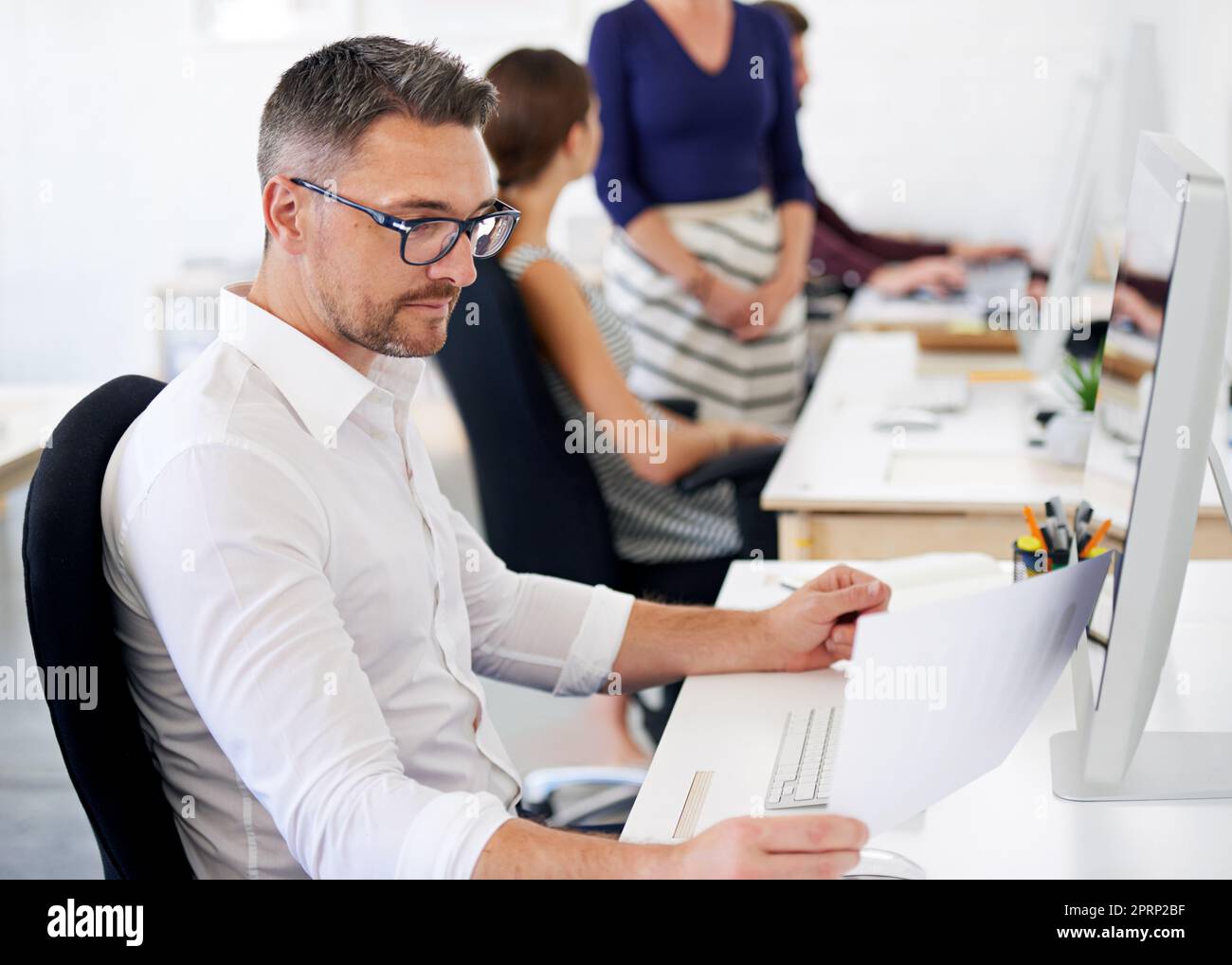 Cent pour cent concentré. Un homme concepteur travaillant sur son ordinateur de bureau. Banque D'Images