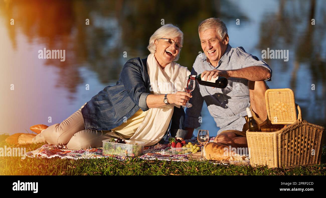 Garder le romantisme vivant. Un heureux couple senior qui profite d'un pique-nique à l'extérieur. Banque D'Images