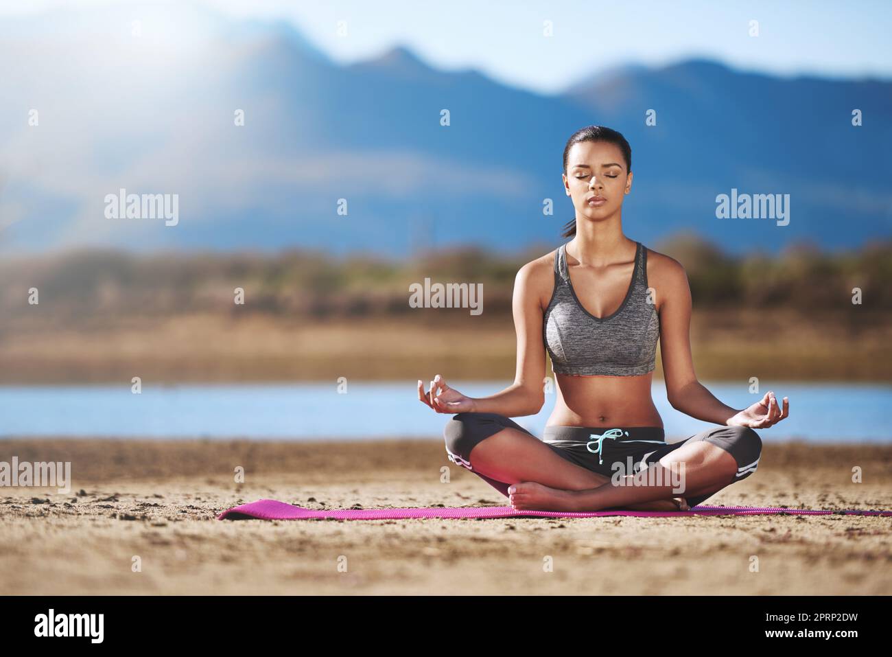 Vous créez votre propre calme. Une jeune femme pratiquant le yoga en plein air. Banque D'Images