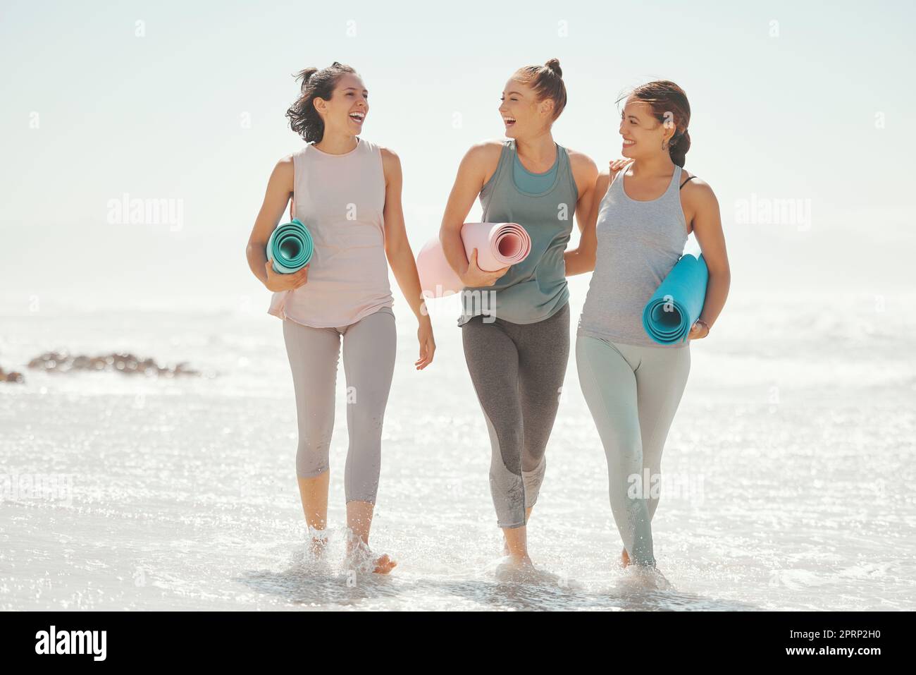 Beach yoga, les femmes de fitness et les amis heureux excités, sourire et rire pour l'exercice, l'entraînement frais et le bien-être du corps à la mer. Des gens en bonne santé qui marchent, l'été l'océan pilate l'entraînement et l'énergie solaire Banque D'Images