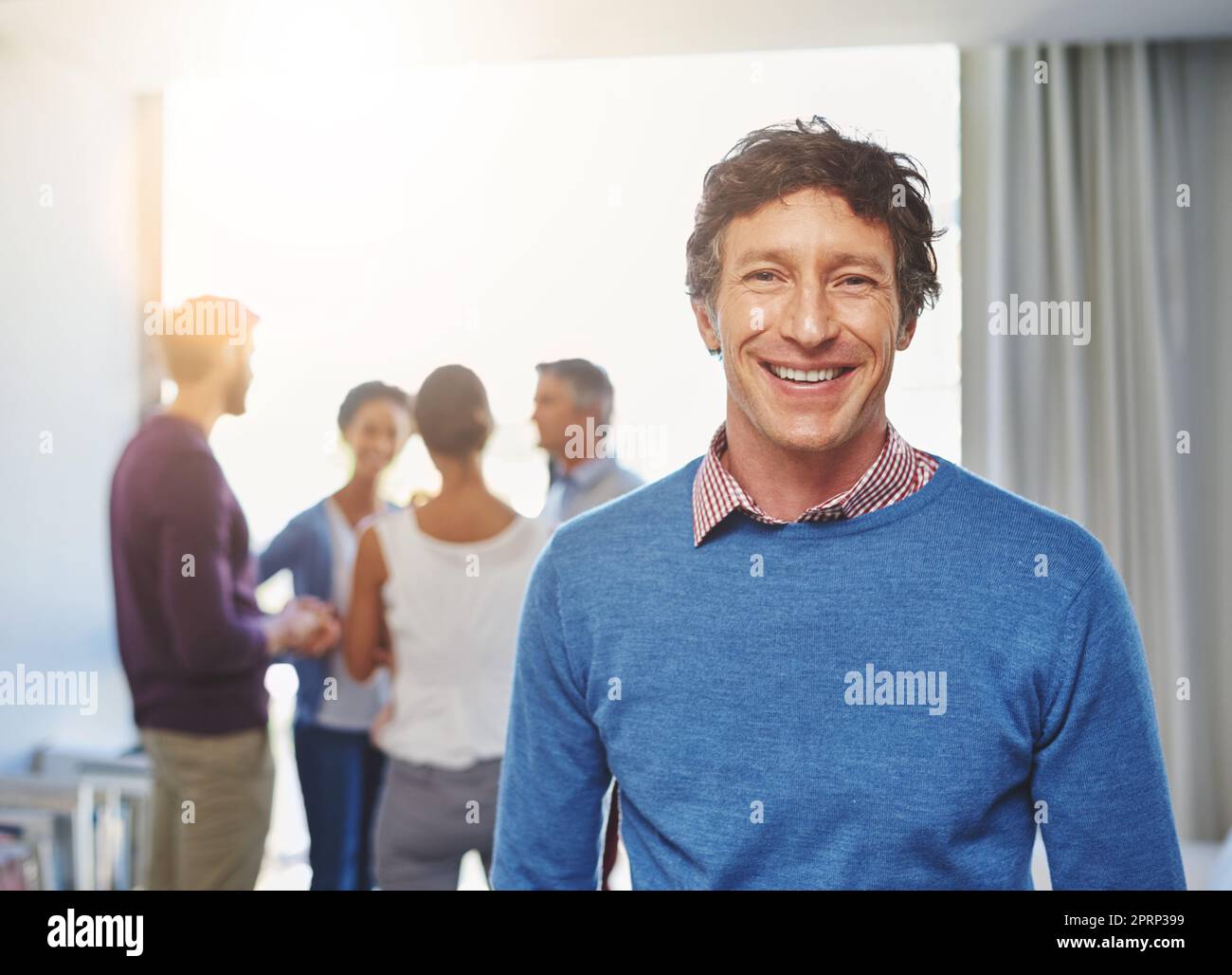 Se sentir bien dans sa carrière. Portrait d'un homme d'affaires avec ses collègues debout en arrière-plan. Banque D'Images