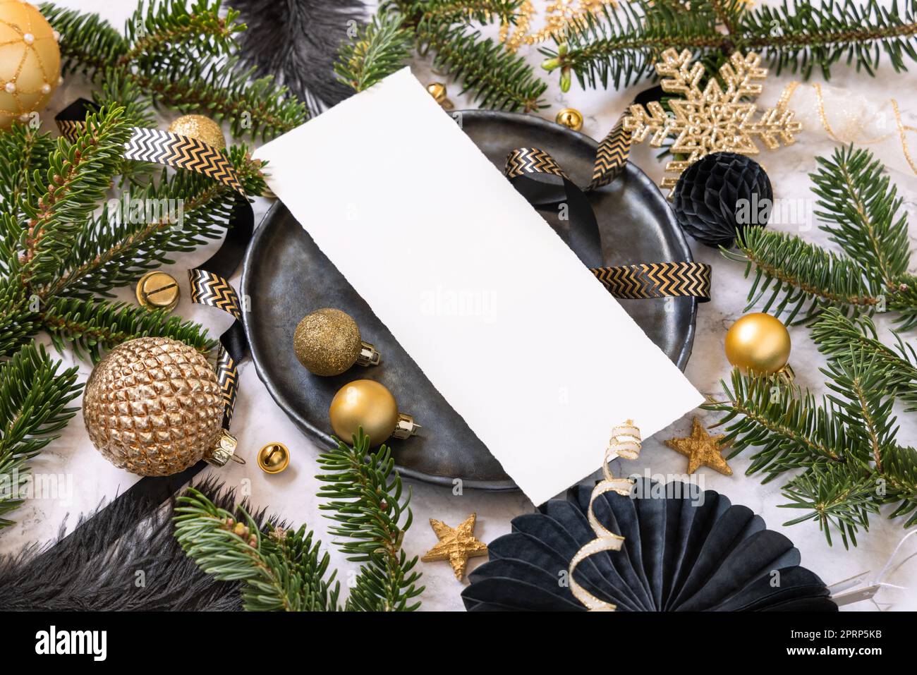 Table de Noël noire et dorée avec ornements et branches de sapin. Maquette de carte de menu Banque D'Images