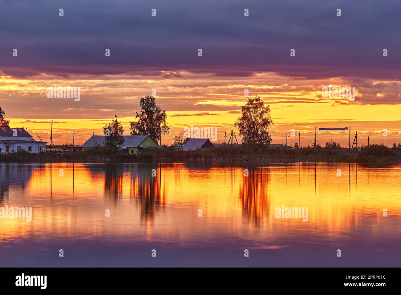 Coucher de soleil d'été sur le lac. Paysage rural naturel, automne septembre soir. Village au bord du lac. Scène rurale crépuscule. Paysage de tempête Banque D'Images