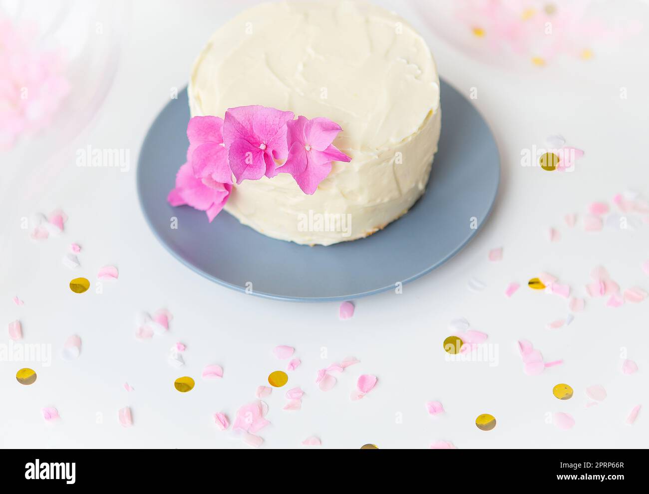 Très beau petit gâteau blanc bento, décoré de fleurs fraîches d'hortensias roses. Concept de vacances et de divertissement. Banque D'Images