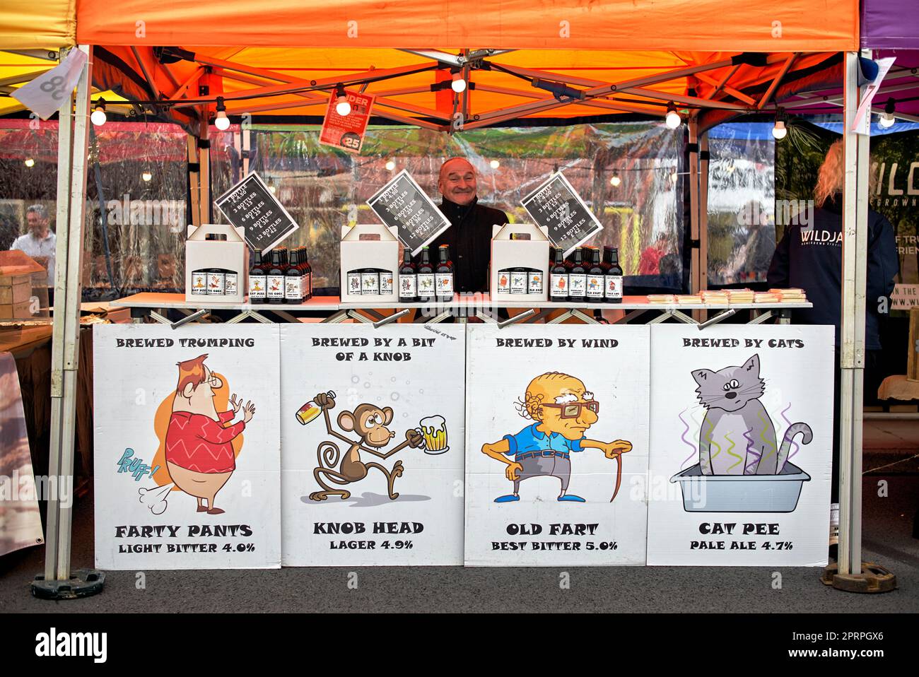 Des affiches amusantes faisant la promotion de la vente d'alcool dans un marché de rue. Angleterre Royaume-Uni Banque D'Images