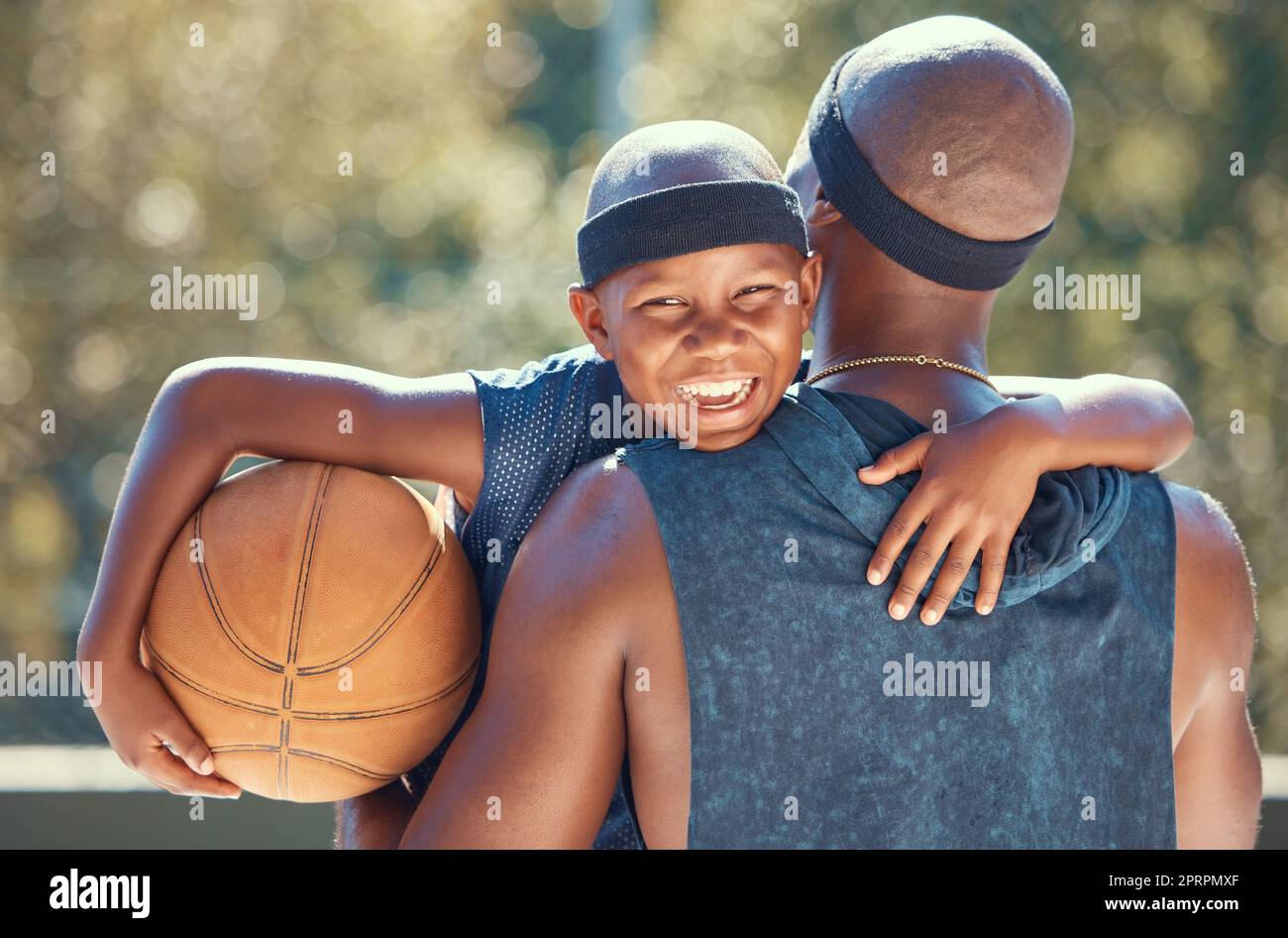 Portrait d'un garçon heureux avec père et basket-ball en plein air après l'entraînement, l'entraînement ou l'entraînement. Père noir portant son garçon après avoir joué au sport dans un club ou un terrain pendant l'été avec un sourire mignon Banque D'Images
