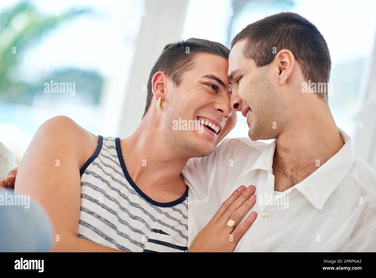 Rire et amour. Un couple gay se détendant ensemble à la maison Banque D'Images