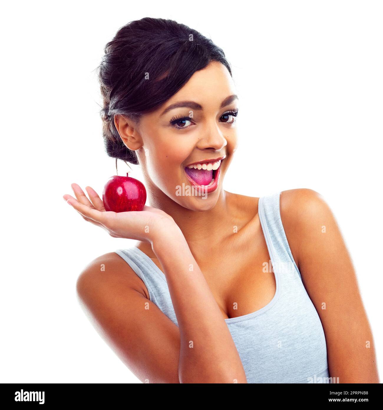 Un enthousiasme sain. Une jeune femme en tenues de gymnastique tenant une pomme et souriant à la caméra Banque D'Images