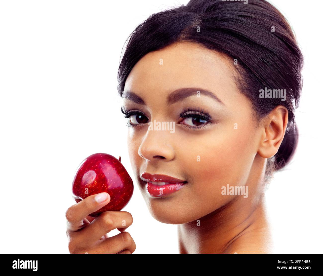 Beauté améliorée par des habitudes alimentaires saines. Une jeune femme en tenues de gymnastique tenant une pomme et souriant à la caméra Banque D'Images