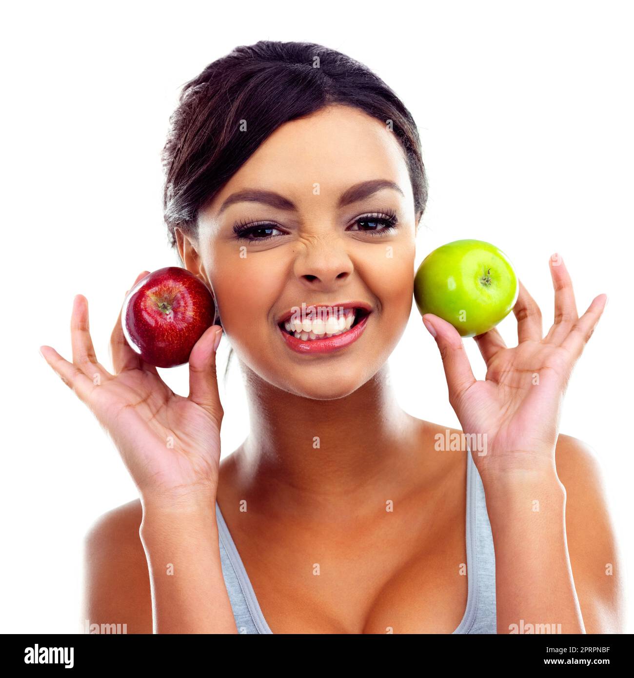 Faire des choix sains. Une jeune femme en tenue de gymnastique tenant deux pommes et souriant à la caméra Banque D'Images