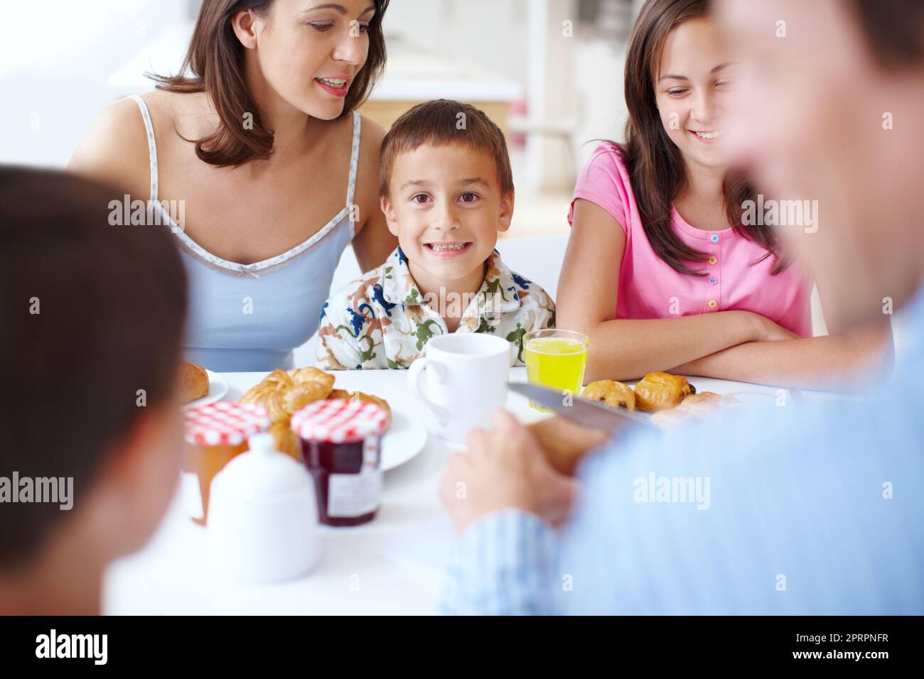 Il peut à peine contenir son excitation. Portrait d'un adorable petit garçon contrôlant à peine son excitation à la table du petit déjeuner. Banque D'Images