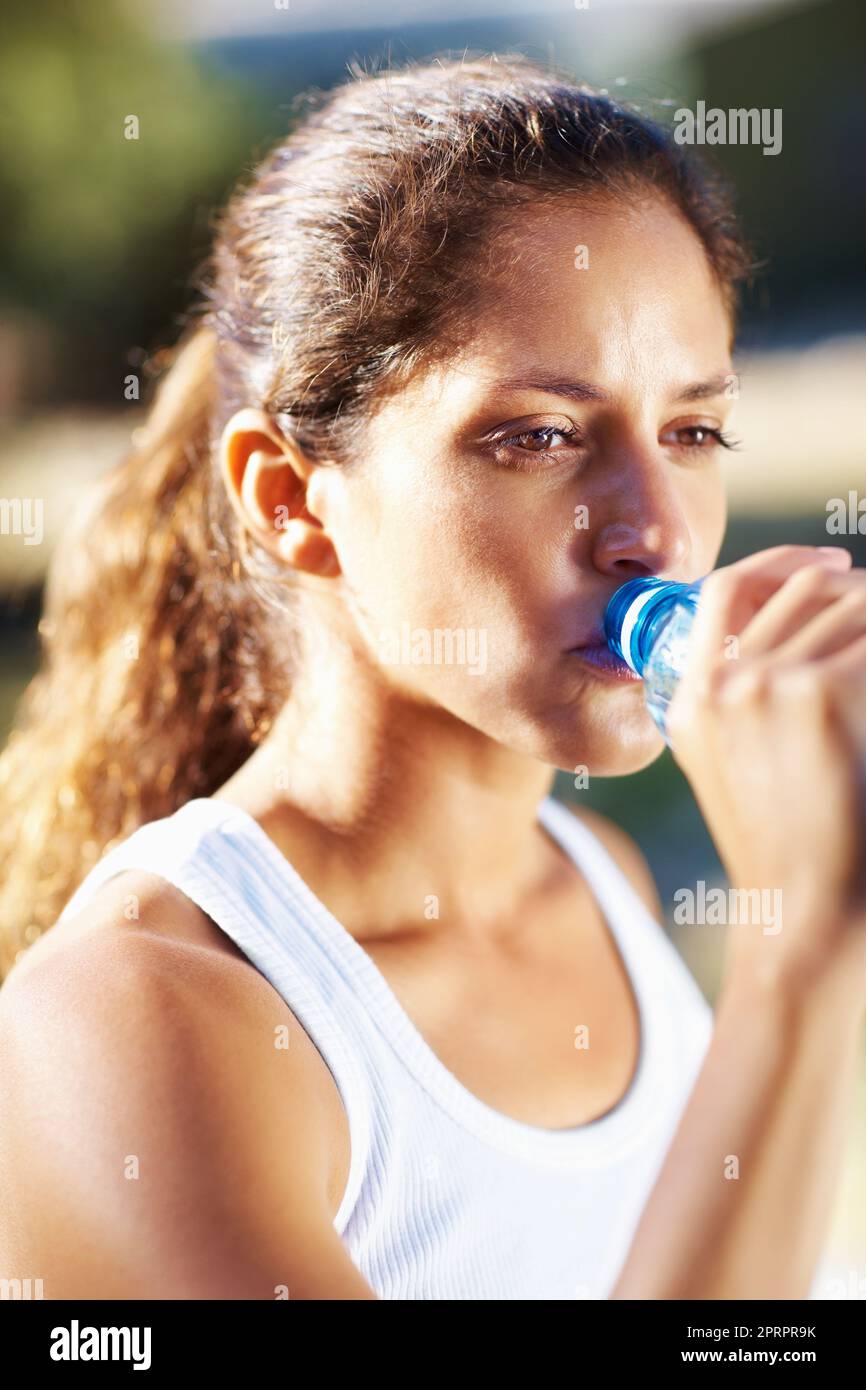 Jolie femme buvant de l'eau. Gros plan de jolie femme de boire de l'eau de la bouteille après l'entraînement. Banque D'Images