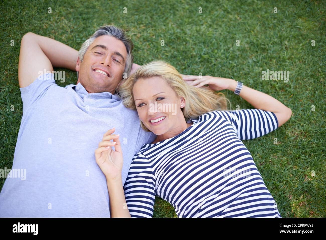 Détente dans le parc. Portrait en grand angle d'un couple mûr allongé dans le parc. Banque D'Images