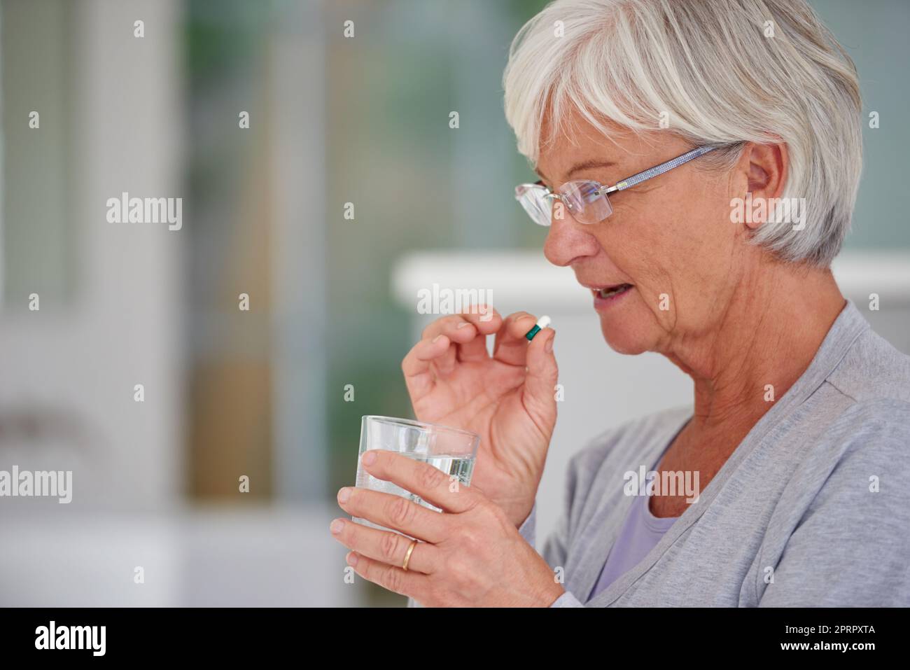 La médecine moderne pour les besoins des aînés. Une femme âgée sur le point de prendre une pilule. Banque D'Images