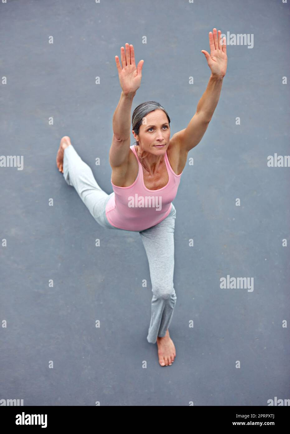 Tissu extensible. Vue en grand angle d'une belle femme mature faisant du yoga à l'extérieur Banque D'Images