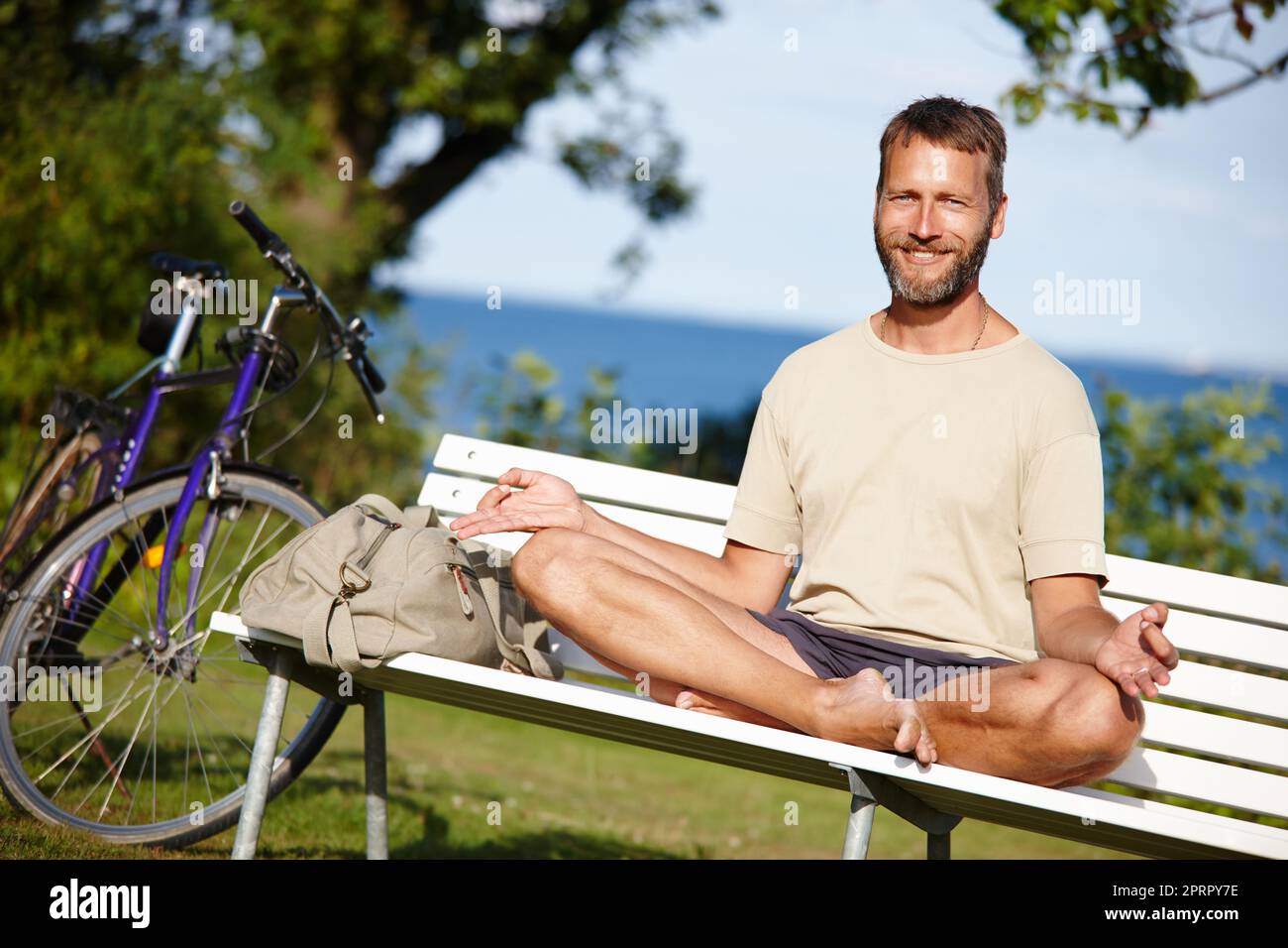 Je viens ici pour méditer. Un homme mûr méditant sur un banc de parc Banque D'Images