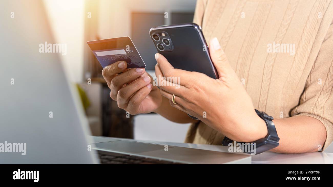Une femme tient sa carte de crédit et son smartphone pour acheter un  produit à la maison Photo Stock - Alamy