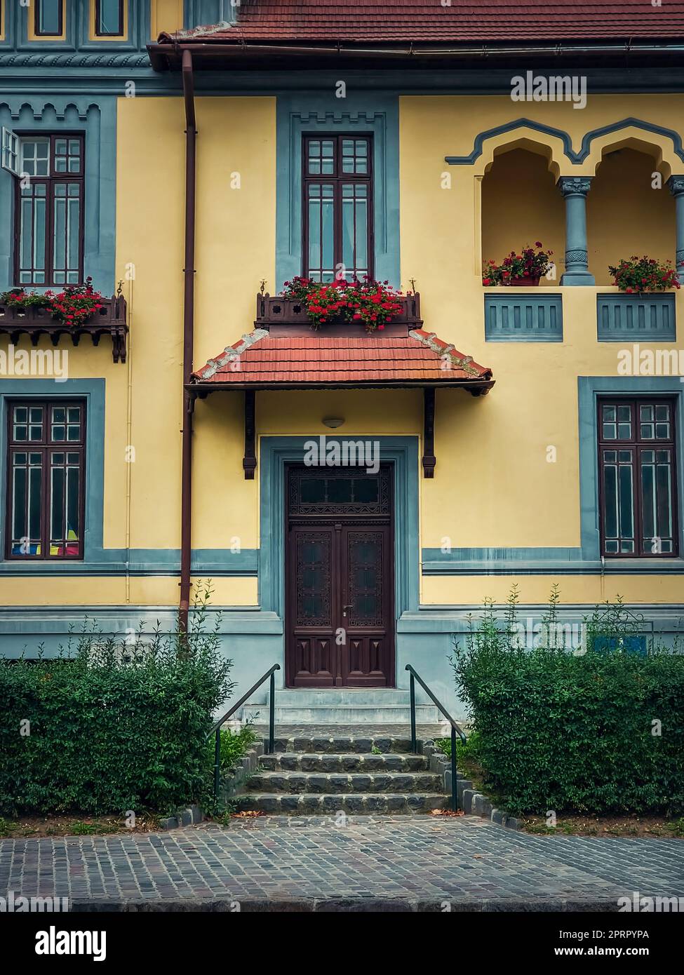 Façade de maison colorée, style vintage avec porche rétro et auvent. Extérieur d'un bâtiment européen traditionnel, vue de face à la porte d'entrée Banque D'Images