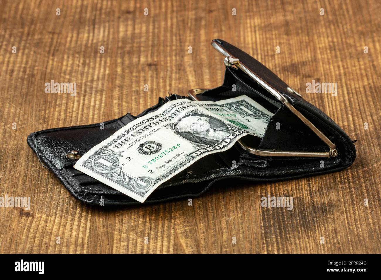 Un dollar américain dans un vieux portefeuille en cuir sur fond de bois Banque D'Images