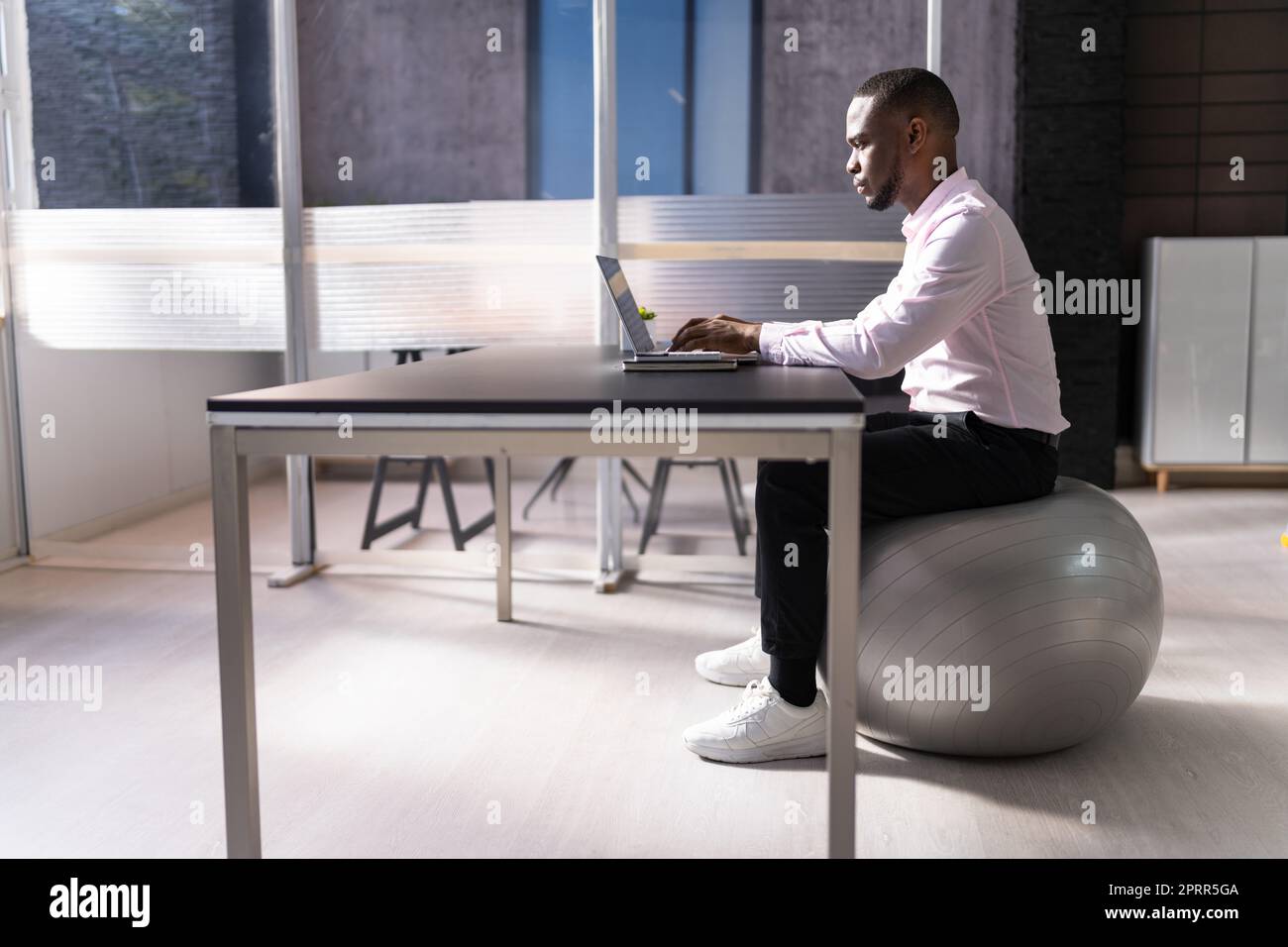 Posture correcte au bureau au bureau à l'aide d'un ballon de fitness Banque D'Images