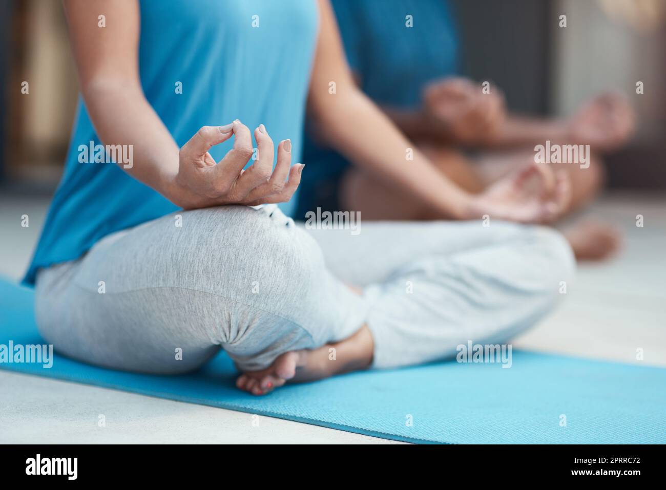 La forme est toujours la clé en matière de yoga. une femme méconnaissable s'engageant dans une posture de yoga assise avec ses jambes croisées Banque D'Images