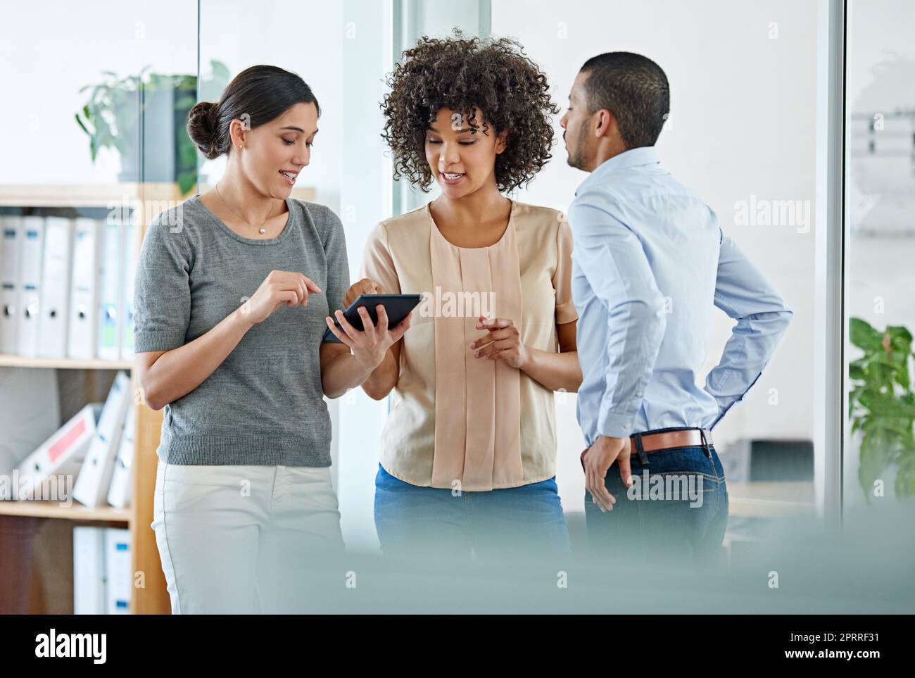 Le travail d'équipe fait le travail de rêve. Collègues de bureau ayant une discussion sur une tablette numérique. Banque D'Images